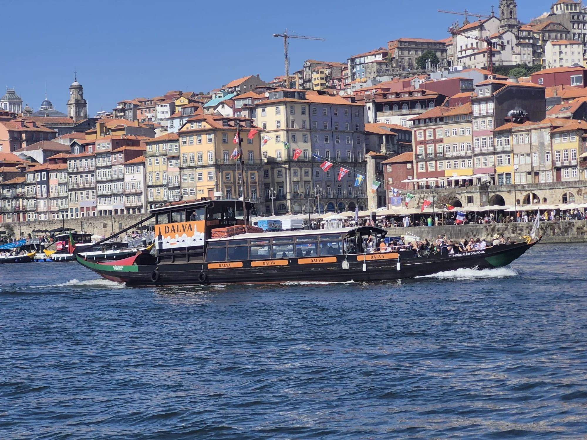 Traditional cruise boat sailing past Porto on the Douro River